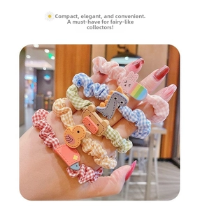 Detailed close-up of colorful plaid hair scrunchies with 3D cartoon animal charms