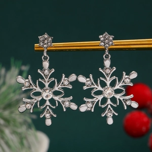 Macro detail of silver snowflake earrings with sparkling rhinestones on festive display