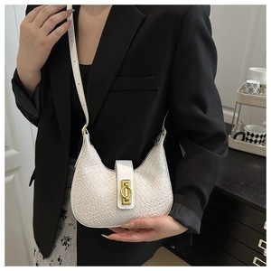 Detail of white woven crescent bag with gold oval buckle on black blazer background