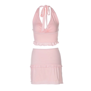 Flat lay of pink summer two-piece set featuring halter crop top and ruffled mini skirt