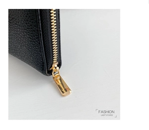 Detailed close-up of premium black lychee leather wallet with gold metal zipper and teeth