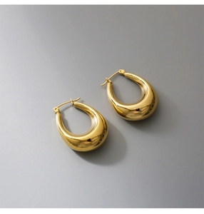 Macro shot of polished gold-plated stainless steel teardrop earrings with stud closure