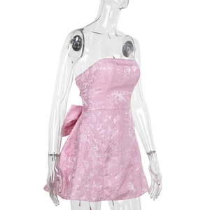 Détail du tissu jacquard rose avec texture florale et nœud au dos de la robe