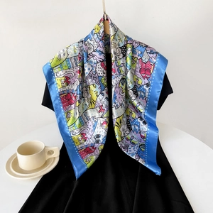 Detailed view of silk-like satin scarf featuring colorful cartoon cat prints and blue borders