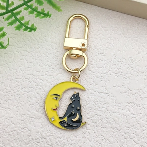 Detail of yellow moon and black cat cartoon charm with gold alloy clasp keychain