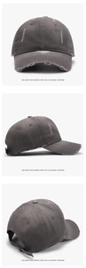 Detail of distressed dark grey cotton baseball cap with worn holes and adjustable strap