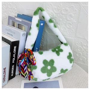Detail of soft white faux fur bag with green floral patterns and geometric silk scarf