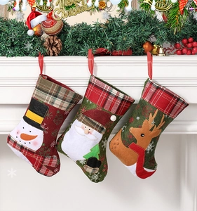 Close-up of three Christmas stockings with Santa, snowman and reindeer on a white fireplace