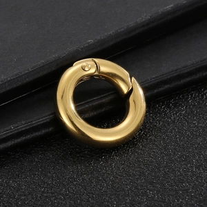 Polished golden stainless steel round spring clasp for jewelry making on black background