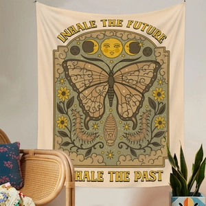 Detail of bohemian tapestry featuring sun moon phases and Inhale the Future text on a wall