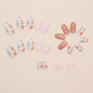 Close-up of clear floral press-on nails in oval shape with orange petals and pink tones
