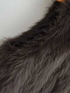 Close-up of the plush dark gray faux fur texture with thick long fibers on a vest