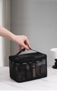 Detail of portable black mesh makeup bag with dual zippers and sturdy top handle