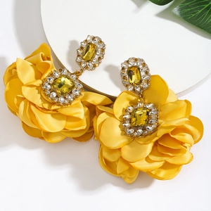 Detail view of yellow fabric camellia earrings with large crystal and diamond accents