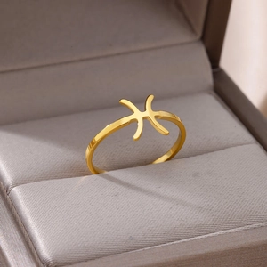 Macro shot of gold Pisces zodiac symbol ring on a velvet jewelry display stand