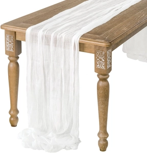Elegante camino de mesa de gasa blanca drapeado con gracia sobre una mesa de madera natural