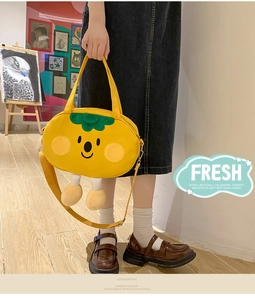 Detail of cute yellow canvas bag featuring 3D doll legs and artistic green leaf decor