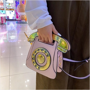 Close-up of pink vintage telephone bag featuring a golden dial and numeric details