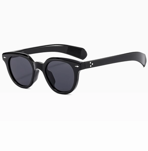Detail of black acetate sunglasses featuring silver diamond studs and star temple accents