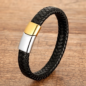Detail of black braided leather bracelet featuring a two-tone gold and silver magnetic clasp