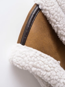 Detail of brown faux suede vest with white sherpa fleece lining and leather trim