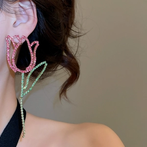 Detail of pink crystal tulip drop earrings with green rhinestone leaves on model