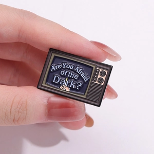 Vintage TV enamel pin with Are You Afraid of the Dark text and burning match design