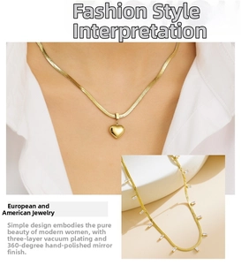 Detail of 18K gold-plated snake chain with heart pendant and zircon tassel layering