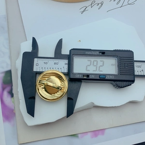 Detail shot showing 25.2mm diameter measurement of the golden floral spiral metal ring
