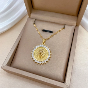 Luxurious gold lion head necklace with sparkling crystals in a beige jewelry box