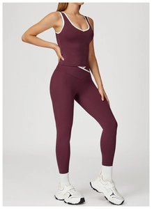 Detail of high-waist crossover yoga pants and burgundy tank top with contrast piping