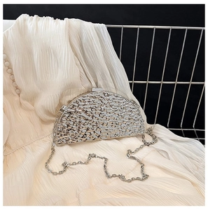 Detail of metallic half-moon evening clutch bag with sequin texture and chain strap