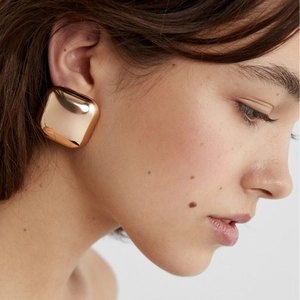 Polished 18k gold plated square stud earrings with rounded corners on model