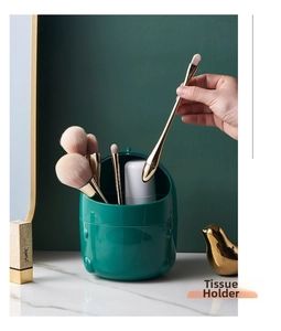 Deep green mini storage bucket used for makeup brushes on a marble desk surface