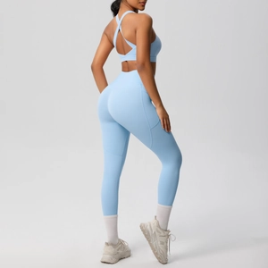Detail of high-waist light blue yoga leggings with side pockets and crisscross sports bra