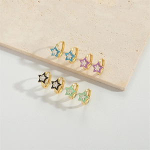 Detail of star-shaped enamel earrings with sparkling zircons in four vibrant colors