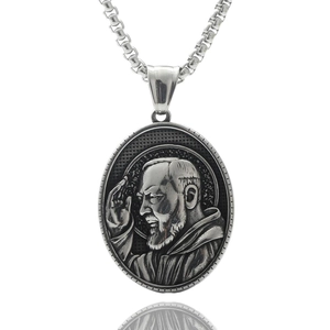 Macro shot of oval stainless steel pendant with embossed portrait of Saint Padre Pio