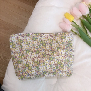 Close-up of a floral cotton makeup bag with yellow blossoms on a soft white background