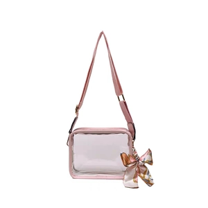 Detailed macro view of pink transparent PVC crossbody bag with silk scarf and canvas strap