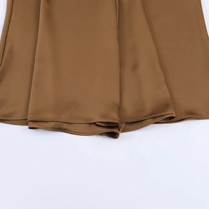 Close-up of brown satin skirt hem showing smooth silk texture and drape detail
