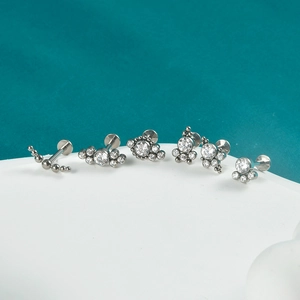 Detailed view of silver G23 titanium labret studs with various opal and crystal designs