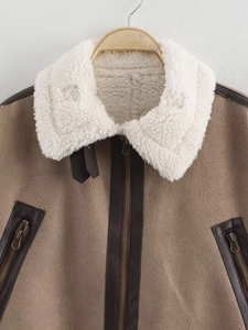 Close-up of vintage brown suede jacket with white faux shearling collar and metal zipper