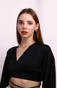 Detail of 18K gold plated daisy necklace and textured hoop earrings on model