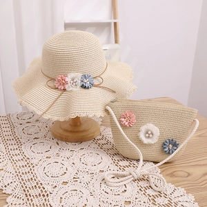Détail d'un ensemble chapeau et sac en paille avec fleurs et perles pour enfants