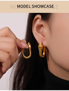 Detail shot of golden snake earring with diamond texture and black crystal eye