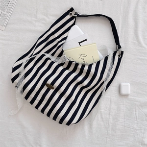 Détail du sac cabas en toile à rayures noires et blanches avec bordure en dentelle