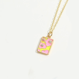 Macro shot of rectangular pink floral pendant with yellow base and sparkling zircons