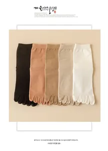 Flat lay of five-toe knitted socks in black, brown, beige, and white cotton blend