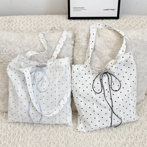 Close-up of heart pattern canvas tote bags showing texture and soft drawstring details