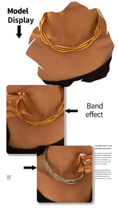 Detailed view of triple-layered gold snake chain necklace on model neck